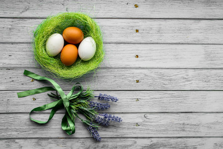 Eggs in the nest and flowers. Spring composition for the Easter holiday. Eggs in the nest, chalk board with a wish. Flowers. Traditional rustic. Wooden blue background. Holiday symbol.の写真素材