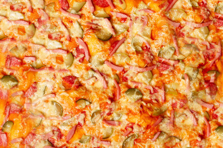 Surface of baked homemade pizza close-up with salami, sausage, cheese, herbs. Background, wallpaper...