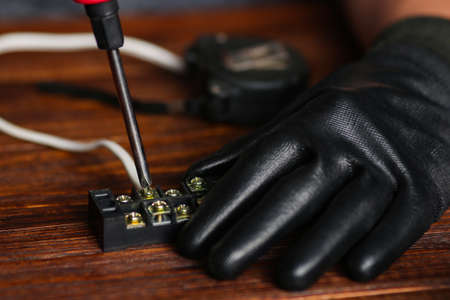 Electrician hands connecting wires in terminal block. Connection of wires with clamps. An electrician man assembles an electrical circuit.の写真素材