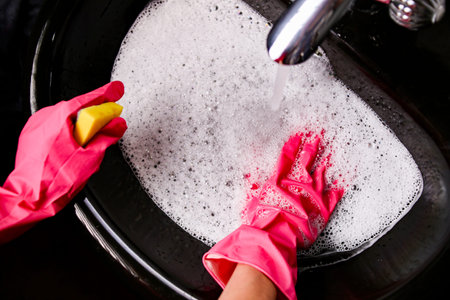 A lot of white foam from cleaning products in the black sink, cleaning the bathroom, cleaning...