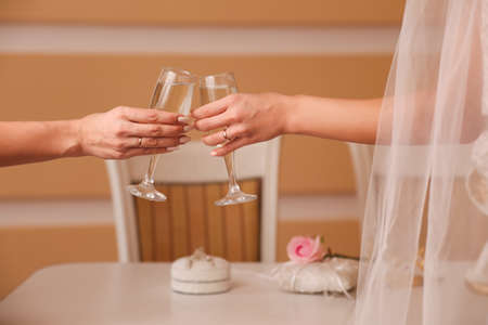 Two glasses with sparkling champagne in hands, holiday concept, weddingの写真素材