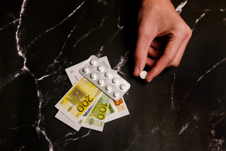 Addicts hand with money buying a dose of cocaine, heroin or other drug from a drug dealer. Drug...
