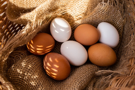 Raw fresh chicken eggs in the village in a rustic wicker basket.