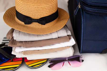 Beach hat, sunglasses and accessories. Luggage, travel items, suitcase and hat. Preparing for vacation or travel.の写真素材