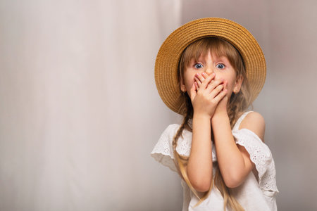 Girl covers her mouth with her hands, smoke indoorsの写真素材