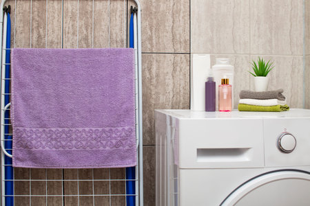 Bathroom, interior, shower set, shampoo, hand and body towels. Washing machine in the bathroom,...