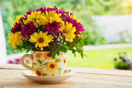 Composition of flowers in a tea mug on a wooden table in the morning in summer or spring. Postcard good morning, Happy Mothers Day, March 8th.の写真素材
