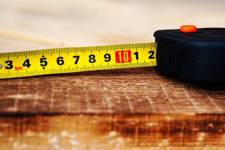 unfolded measuring tape on a wooden board.
