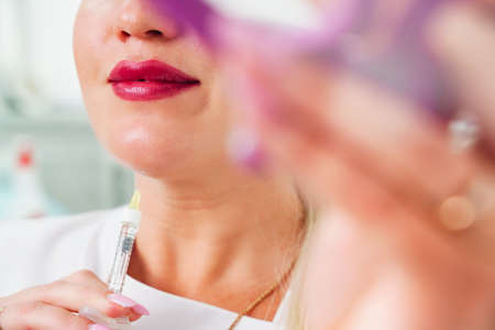 Cosmetologist makes lipolytic injections to burn fat on the chin against double chin. Female aesthetic cosmetology in a beauty salon. Cosmetology conceptの写真素材