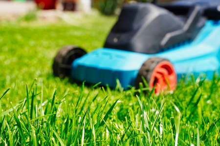 Blurred lawnmower electric machine trimming and focus on green grass. Lawn cuttingの写真素材