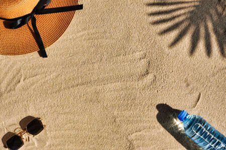 Summer minimal background with wicker hat, colored sunglasses on sandy color background with sun shadows and copy space. Summertime concept pastel colored aesthetic photo.の写真素材
