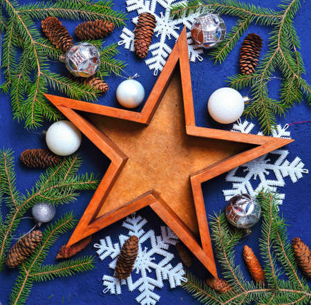 Christmas and New Years Eve composition - wooden star with fluffy pine branches, white Christmas balls and cones, snowflakes. New Year, Christmas, winter holidays.の写真素材