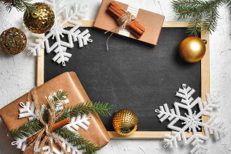 Christmas background. Christmas fir tree branches, gifts, pine cones on black board rustic background. Flat lay, top view. Copy space. Banner backdrop compositionの写真素材