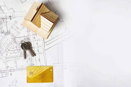 Model of a house and key ring, plan project and drawings on paper with copy spaceの写真素材