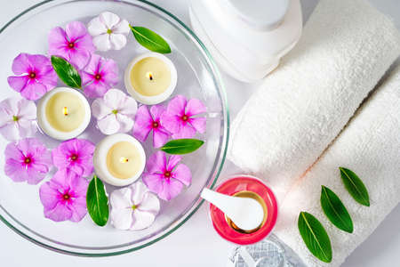 Face and body care products with pink flowers. Freshness and body care. Skin cosmetics. White clear towels for purityの写真素材