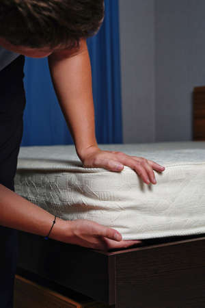 Young man choosing new orthopedic mattress close upの写真素材