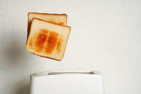 Toast pops out of the toaster, morning breakfast in the kitchen, fried bread health benefits