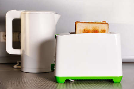 White kettle and toaster mockup stand on a kitchen table on a gray wall backgroundの写真素材