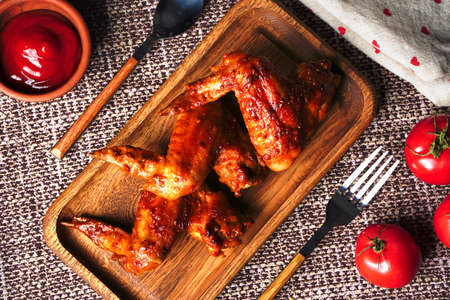 Homemade food grilled chicken wings with sauce and tomatoesの写真素材