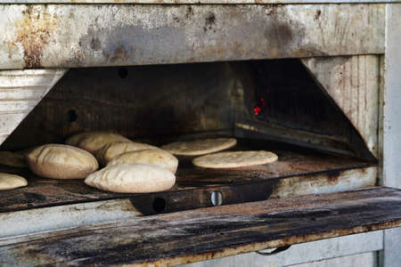 Pita hot bread from the oven. Freshly baked gluten-free flatbread or pitta. Fluffy, round bread to be stuffed with food.の写真素材