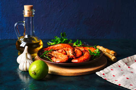 Grilled cooked argentine prawns, shrimps langoustines with herbs, garlic and lemon on a dark background with copy spaceの写真素材