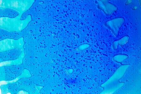 Transparent clear blue liquid serum gel smudge with bubbles textured backgroundの写真素材