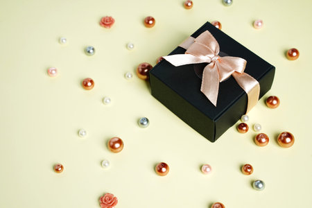 Black holiday gift box with bow on top view background. Birthday surprise, Christmas present and...
