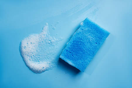 Cleaning blue sponge and a soapy foam on a background. Cleaning concept, cleaning service. Banner. Flat lay, top view. High quality photoの写真素材