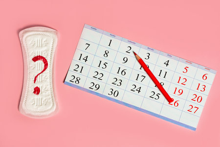 Woman menstrual calendar, control of the regular cycle, pencil and sanitary pad napkin with a question.の写真素材