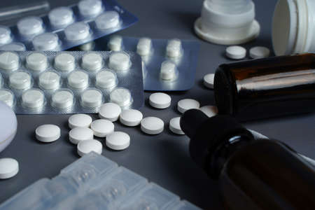 Medical therapy, ampoule vials, tablets, nasal spray and syringe on gray backgroundの写真素材