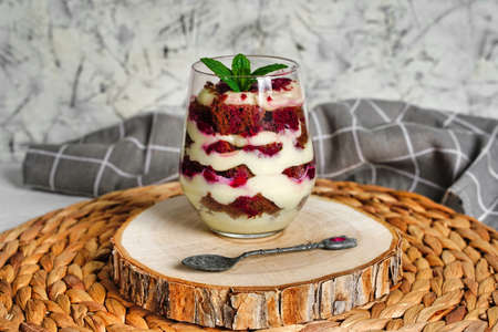 Transparent glass with layered dessert, chocolate cake and whipped cream, berriesの写真素材