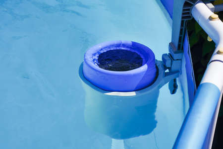 The blue skimmer for cleaning the pool in clear water. Close-up of the skimmer mounted on a frame pool, Control filtration systemの写真素材