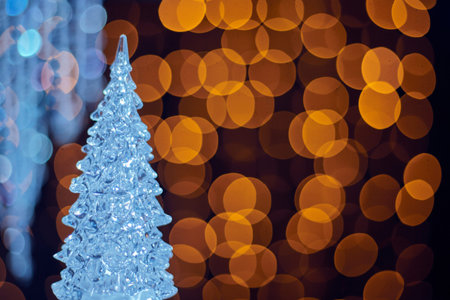 Blurred bokeh golden background with ice Christmas tree. Glittering decorations for the New Year and...