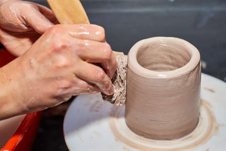 Potter making ceramic pot on the pottery wheel. Modeling of clay on a potter's wheel In the pottery workshopの写真素材