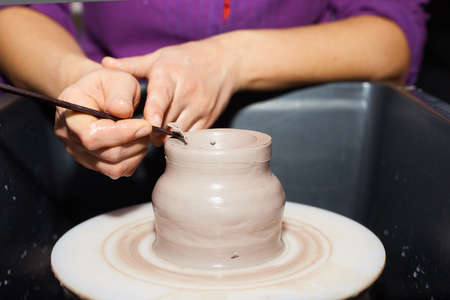 Potter making ceramic pot on the pottery wheel. Modeling of clay on a potter's wheel In the pottery workshopの写真素材