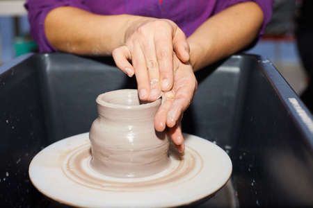 Potter making ceramic pot on the pottery wheel. Modeling of clay on a potter's wheel In the pottery workshopの写真素材