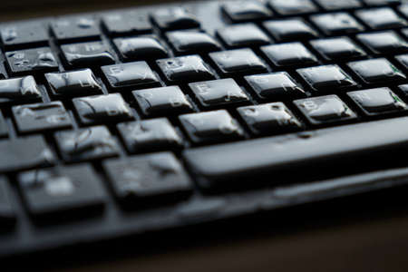 drops of water on a black keyboardの写真素材