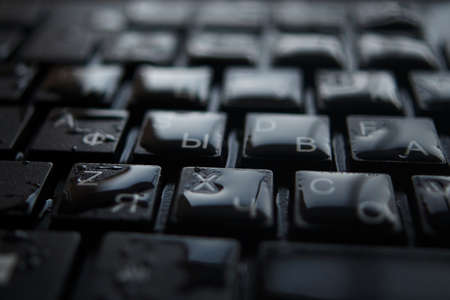 drops of water on a black keyboardの写真素材