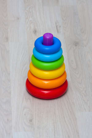 A toy rainbow pyramid on the background of a wooden child's floorの写真素材
