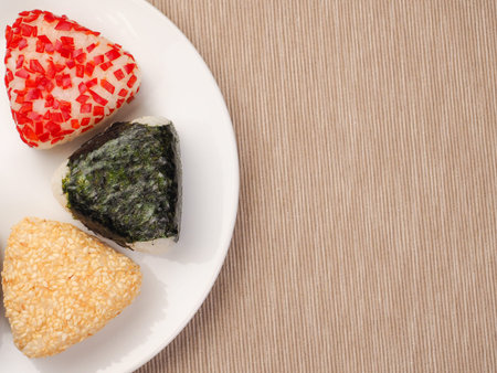 A series of shots of onigiri of various shapes and fillings on a plate. top view. Japanese rice ball.の写真素材