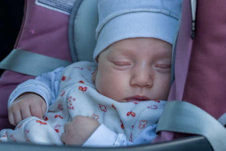 The child sleeps comfortably and safely in the car's child restraint.の写真素材