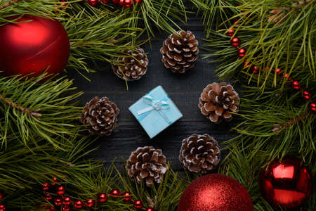 Christmas gift with fir branches, pine cones on old wooden board. new yearの写真素材