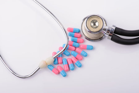colored capsules and stethoscope on a white background