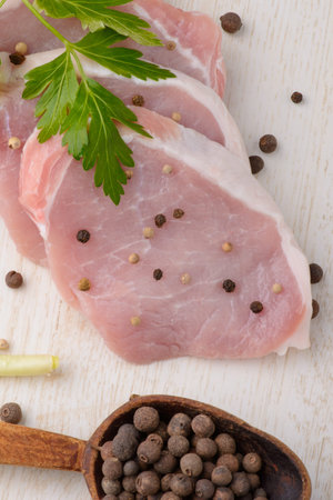 raw meat steak on white wooden board with spoon spiceの写真素材