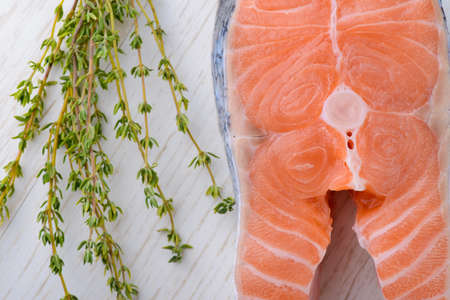 fresh salmon with fresh thyme on a white wooden boardの写真素材