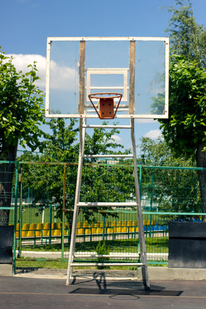 street basketball court, basketball shield with a ring on the background of the sky and green trees