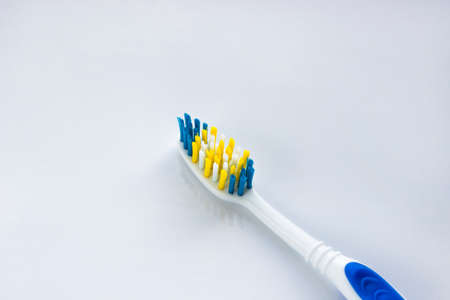 blue and white toothbrush on a white backgroundの写真素材