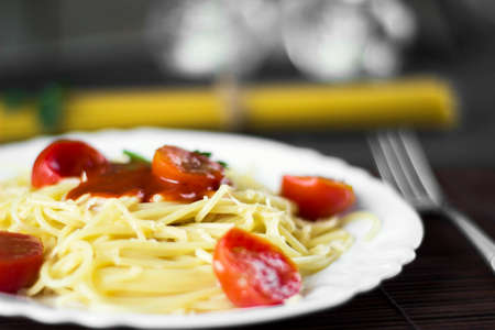 Spaghetti pasta in tomato sauce with cheese and parsley. Italian spaghetti pasta over dark stone background.の写真素材