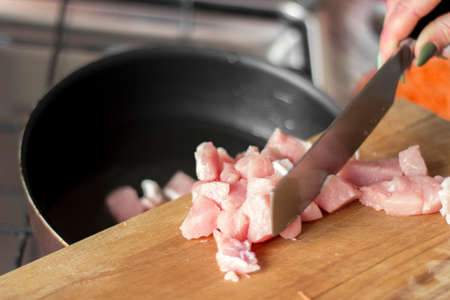 Laying raw pork pieces on a cutting boardの写真素材