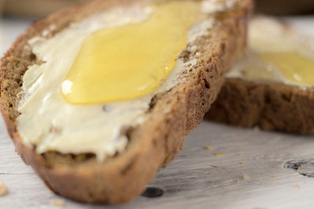 Pieces of bread with butter and honey, macro